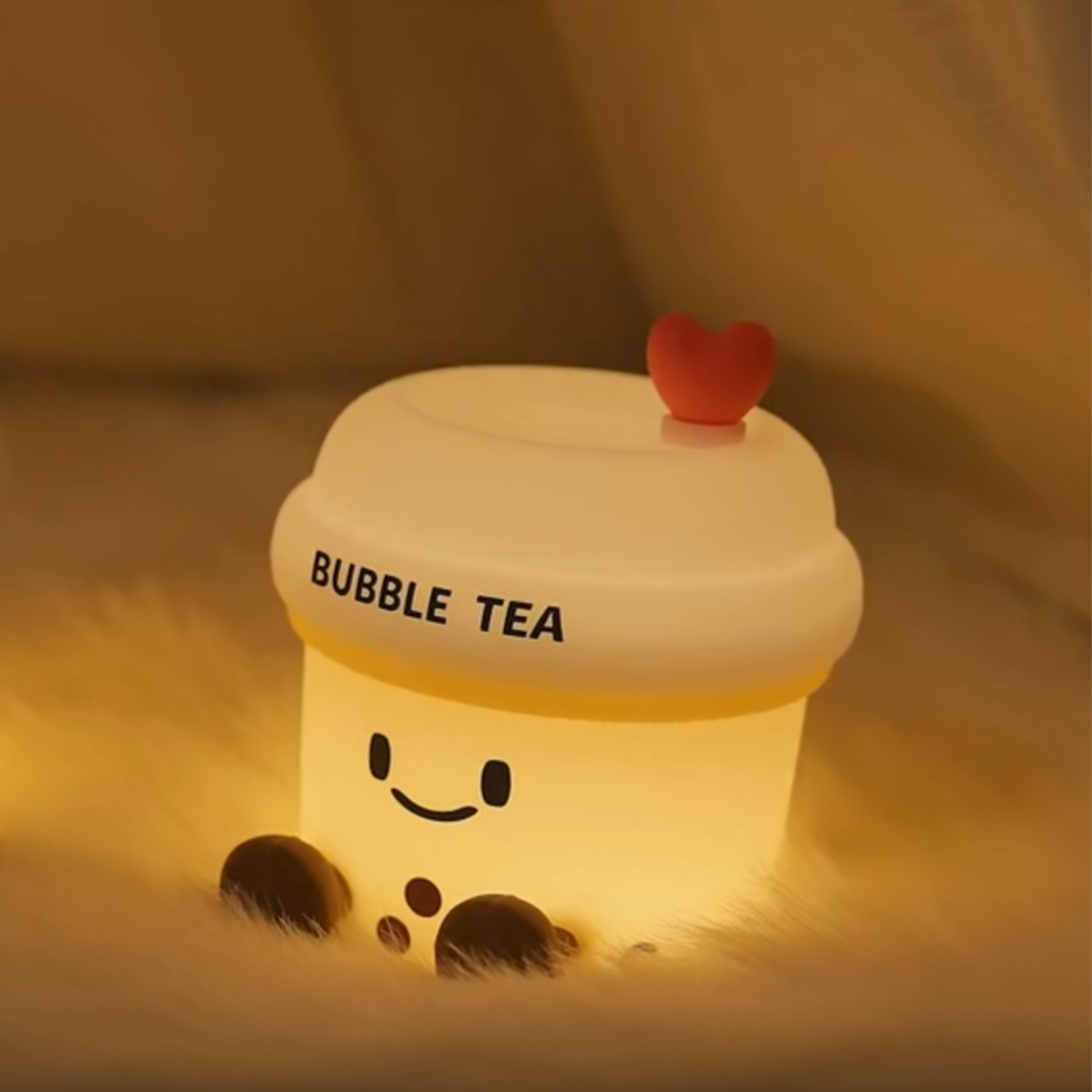 Light-up bubble tea toy with a heart on top, glowing warmly.