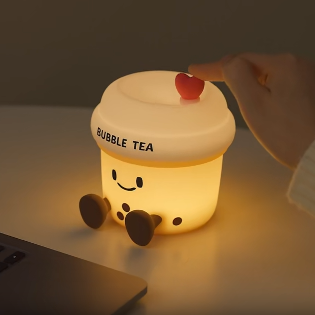 Light-up bubble tea cup-shaped night light on a desk next to a laptop.