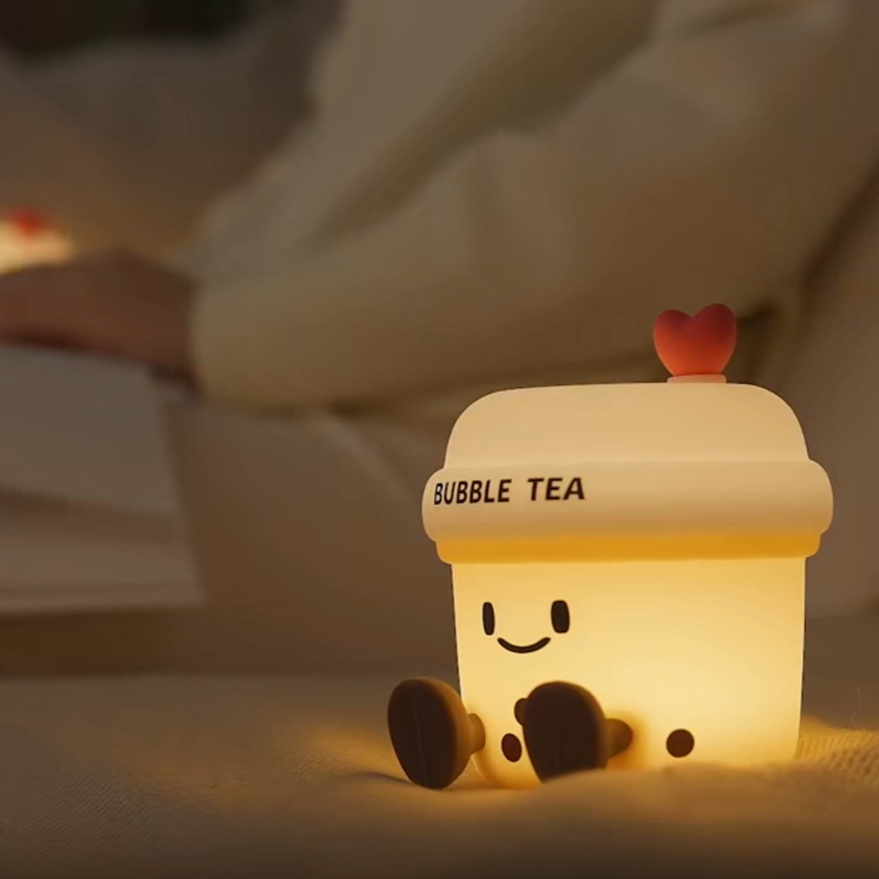 Cute bubble tea-shaped night light on a soft surface with a blurred background