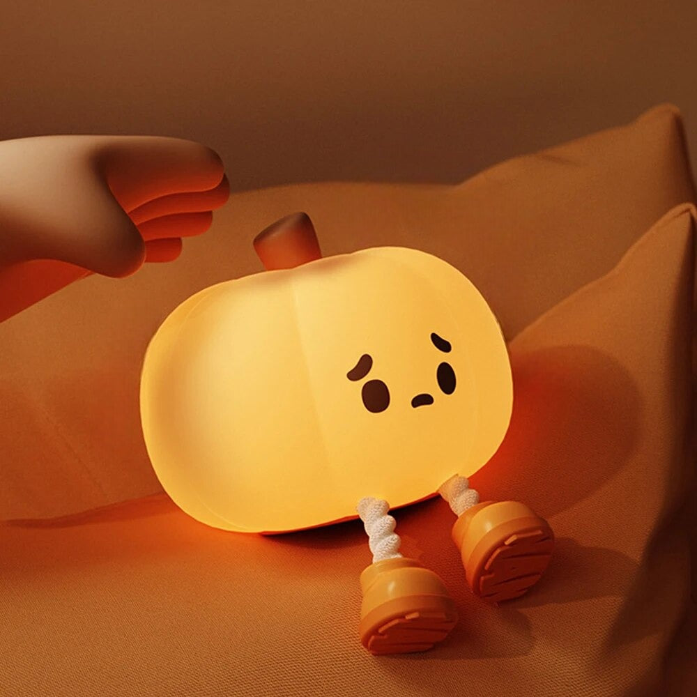 LED Night Light Lamp pumpkin looking sad sitting on a pillow with hand over its body