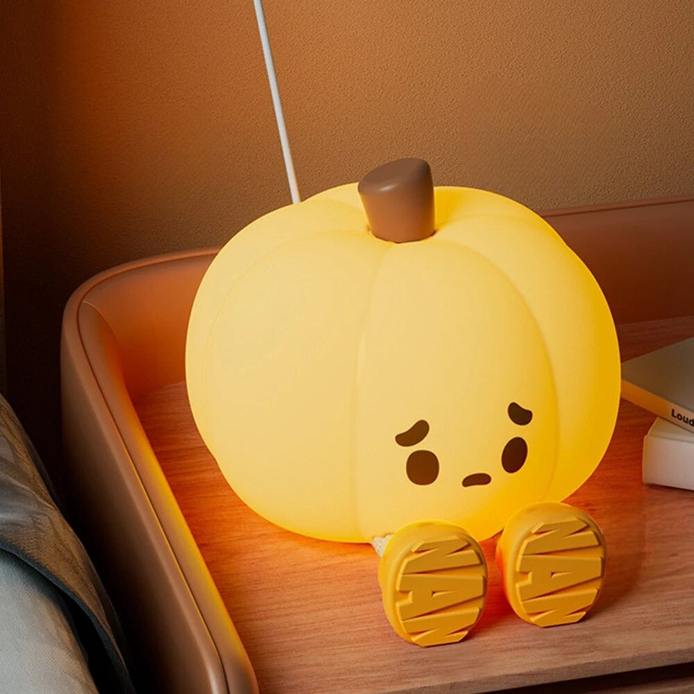 LED Night Light Lamp Pumpkin looking sad while sitting next to bed on a nightstand