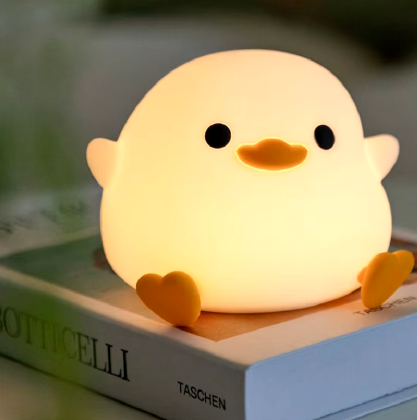LED Night Light Lamp duck sitting on top of a book