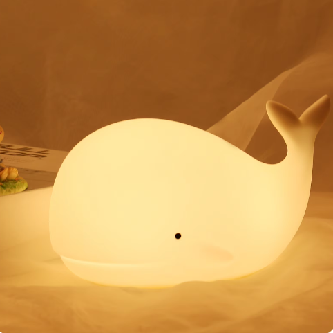 LED whale shaped lamp glowing warm light on a table