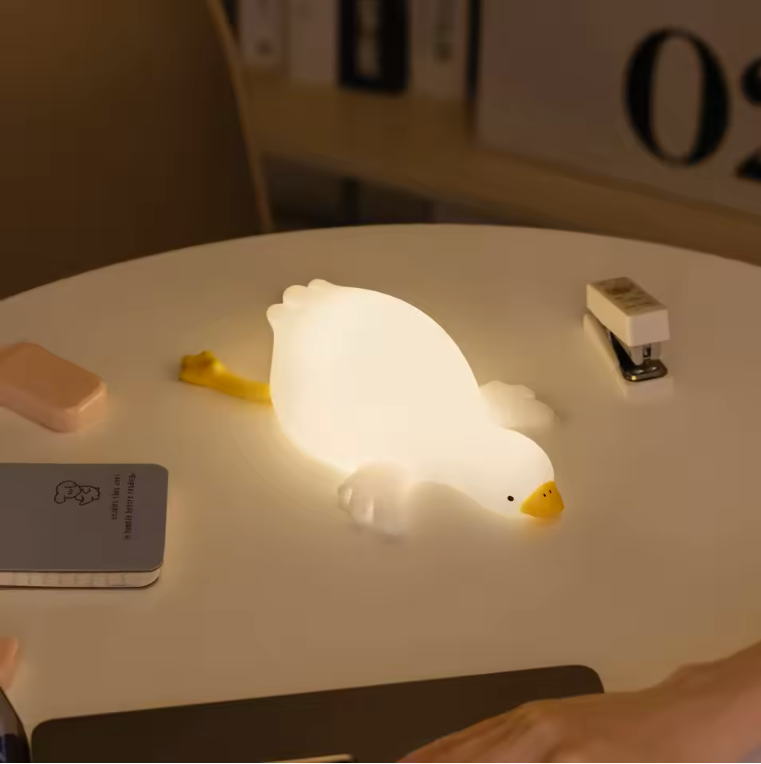 glowing night light shaped like a goose lying down on table