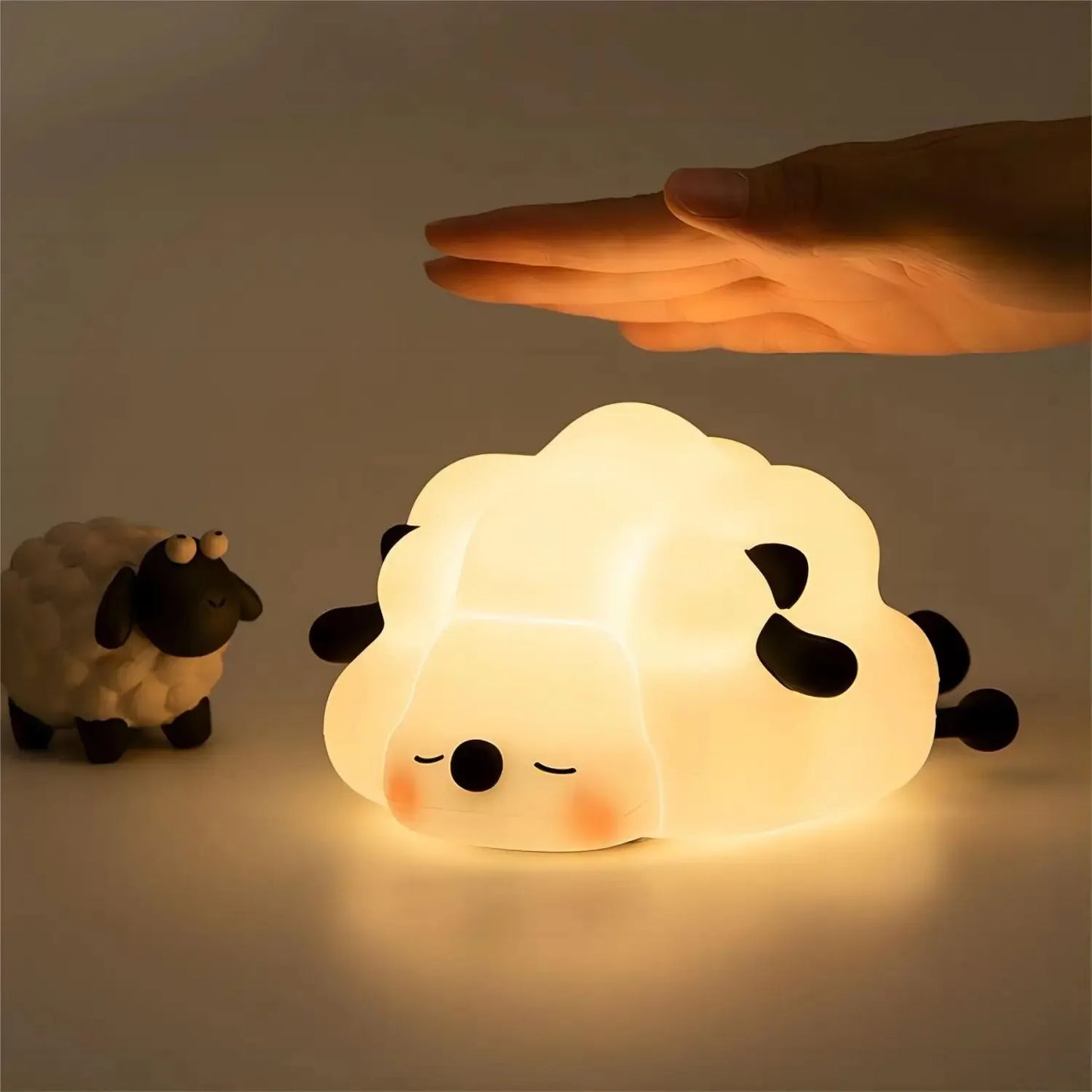 Sheep LED Lamp Glowing blow a human hand place next to a porcelain lamp figurine