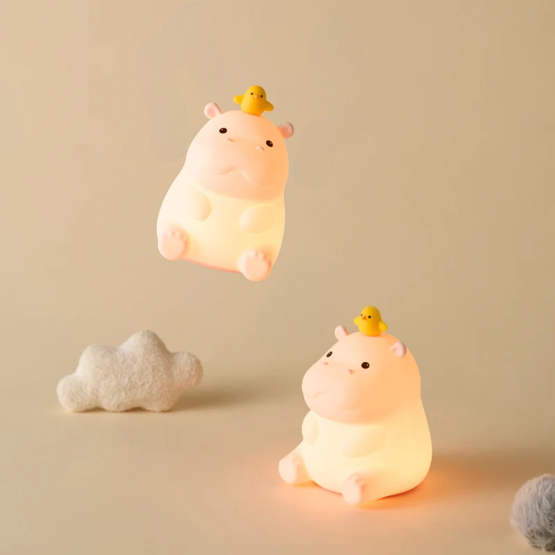 Two cute teacup hippo-shaped night lights with small ducks on a beige background