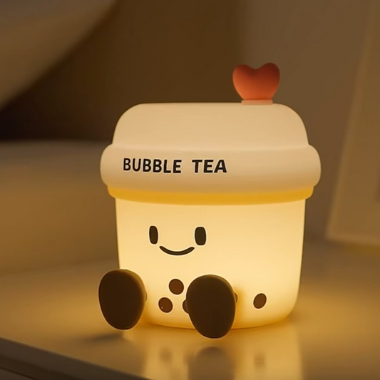 Cute bubble tea-shaped night light with a smiling face on a reflective surface.