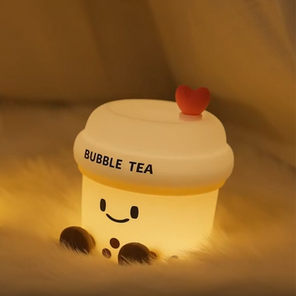 Light-up bubble tea toy with a heart on top, glowing warmly.