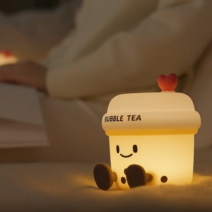 Cute bubble tea-shaped night light on a soft surface with a blurred background
