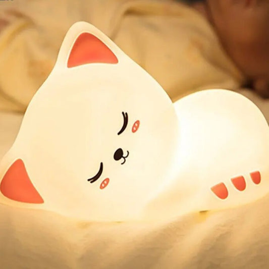 LED Night Light Lamp Kitten laying on a bed with person sleeping behind it
