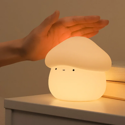 Fantastic Fungi -shaped night light with a hand touching it on a wooden surface.