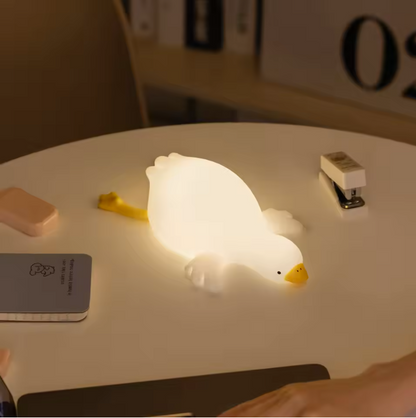 glowing night light shaped like a goose lying down on table
