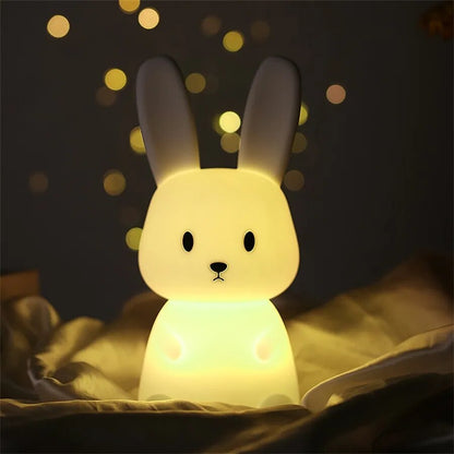 LED Night Light Lamp rabbit sitting on a soft blanket with twinkles in the background