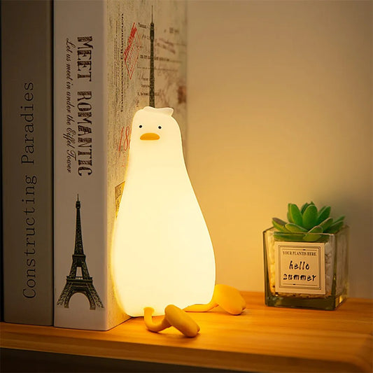 LED Night Light Lamp duck laying against two books on a shelf