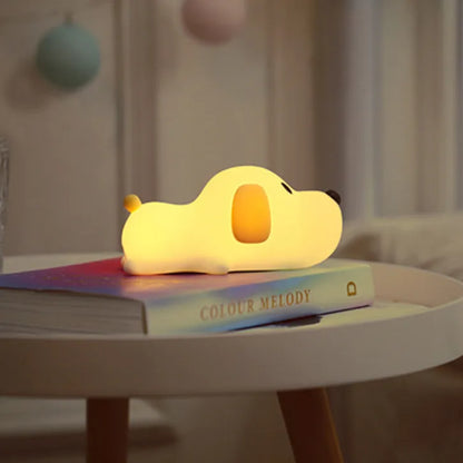Dog shaped Led Night light lamp laying on a book on top of a table