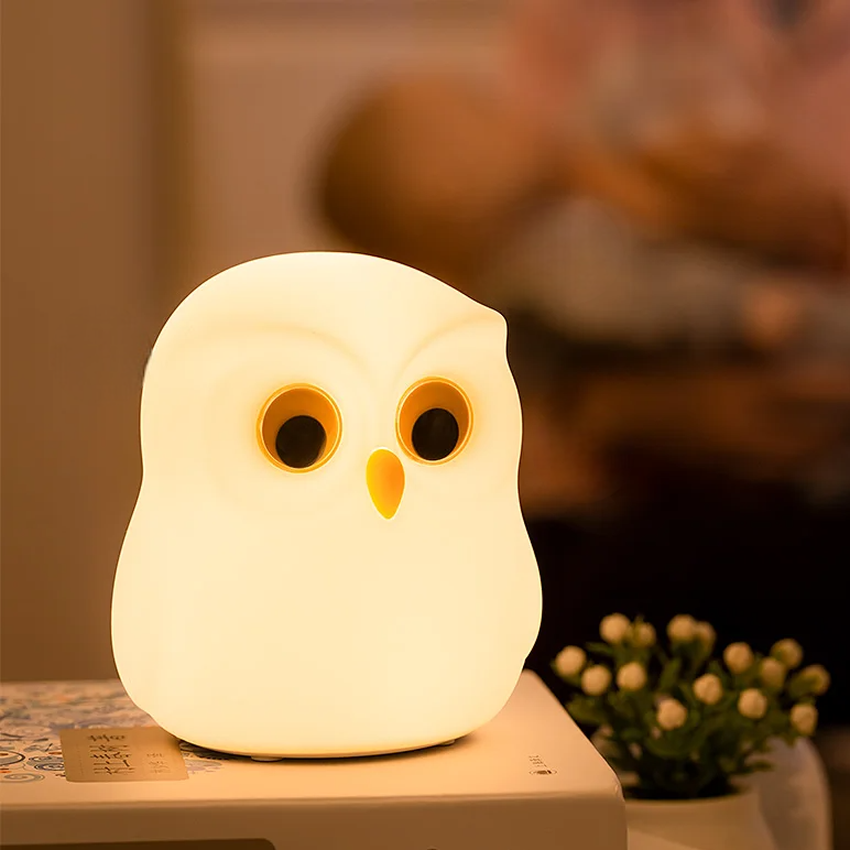 Snowy Owl-shaped night light on a surface with a blurred background by cozzy glow 