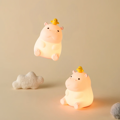 Two cute teacup hippo-shaped night lights with small ducks on a beige background